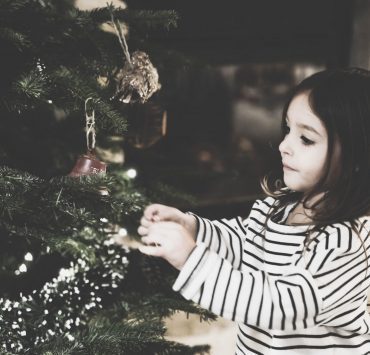 Little girl decorating tree
