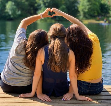 Three girls sitting on dock