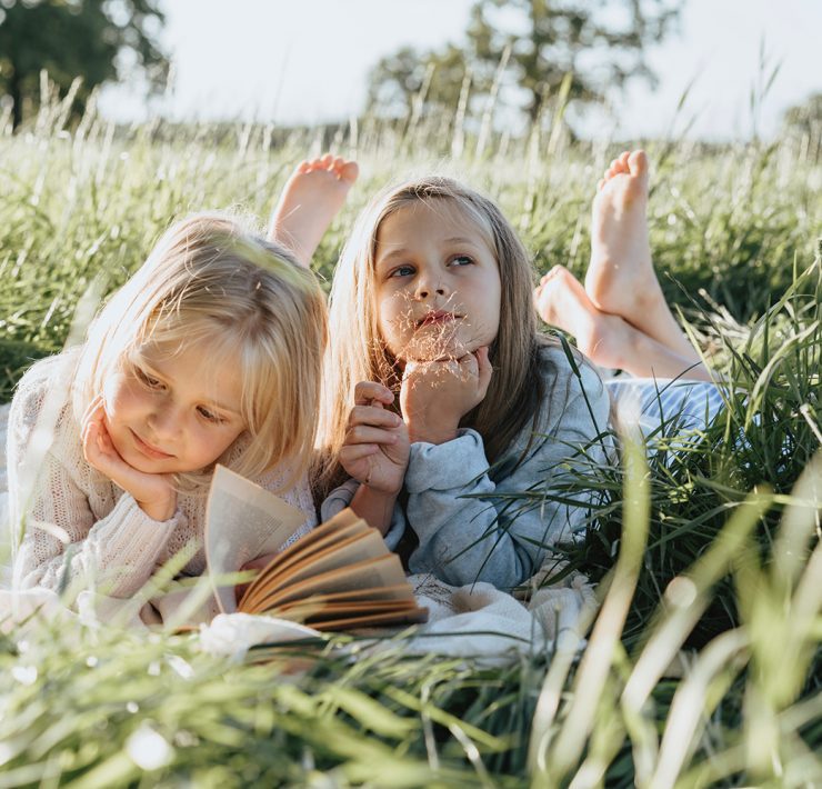 Two girls in a field reading
