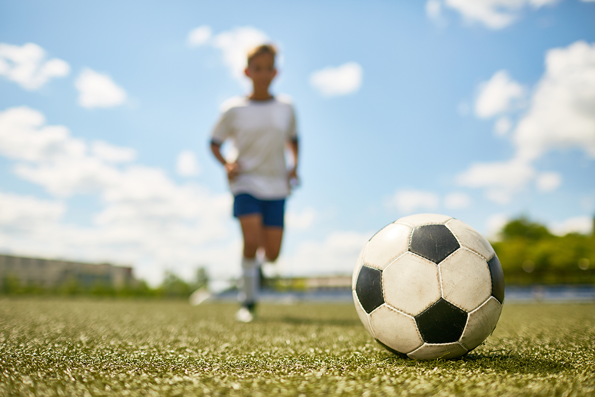 Boy running after soccer ball