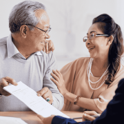 Senior couple reviewing estate planning documents with a lawyer in an office.