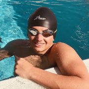 Young swimmer wearing a protective swim cap during summer league practice.