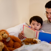 Parent reading a bedtime story to young child before sleep