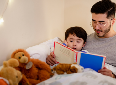 Parent reading a bedtime story to young child before sleep