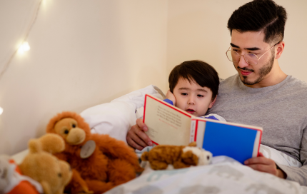 Parent reading a bedtime story to young child before sleep